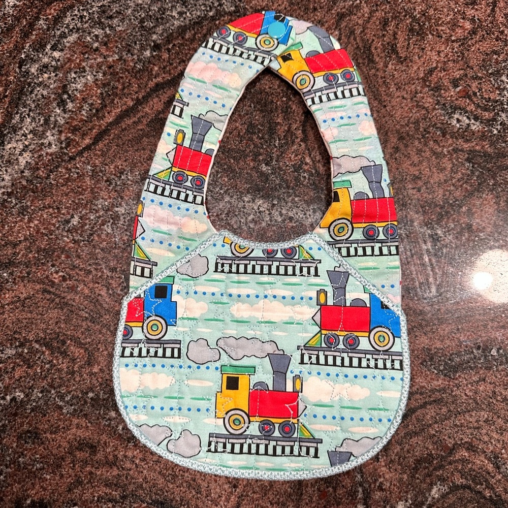 Handmade reversible quilted baby bib with train design